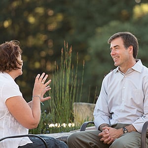 man and woman sitting outside talking