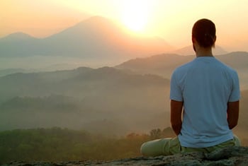 man meditating on a mountaintop