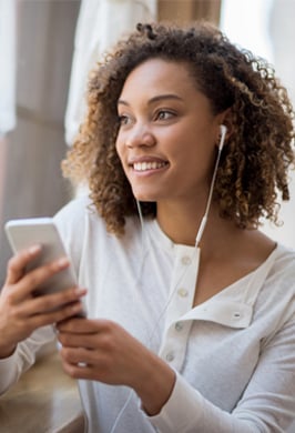 woman listening to her phone and smiling